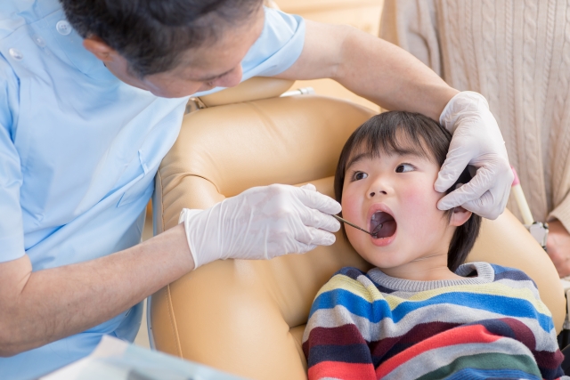 歯科医者と口を開けている子供